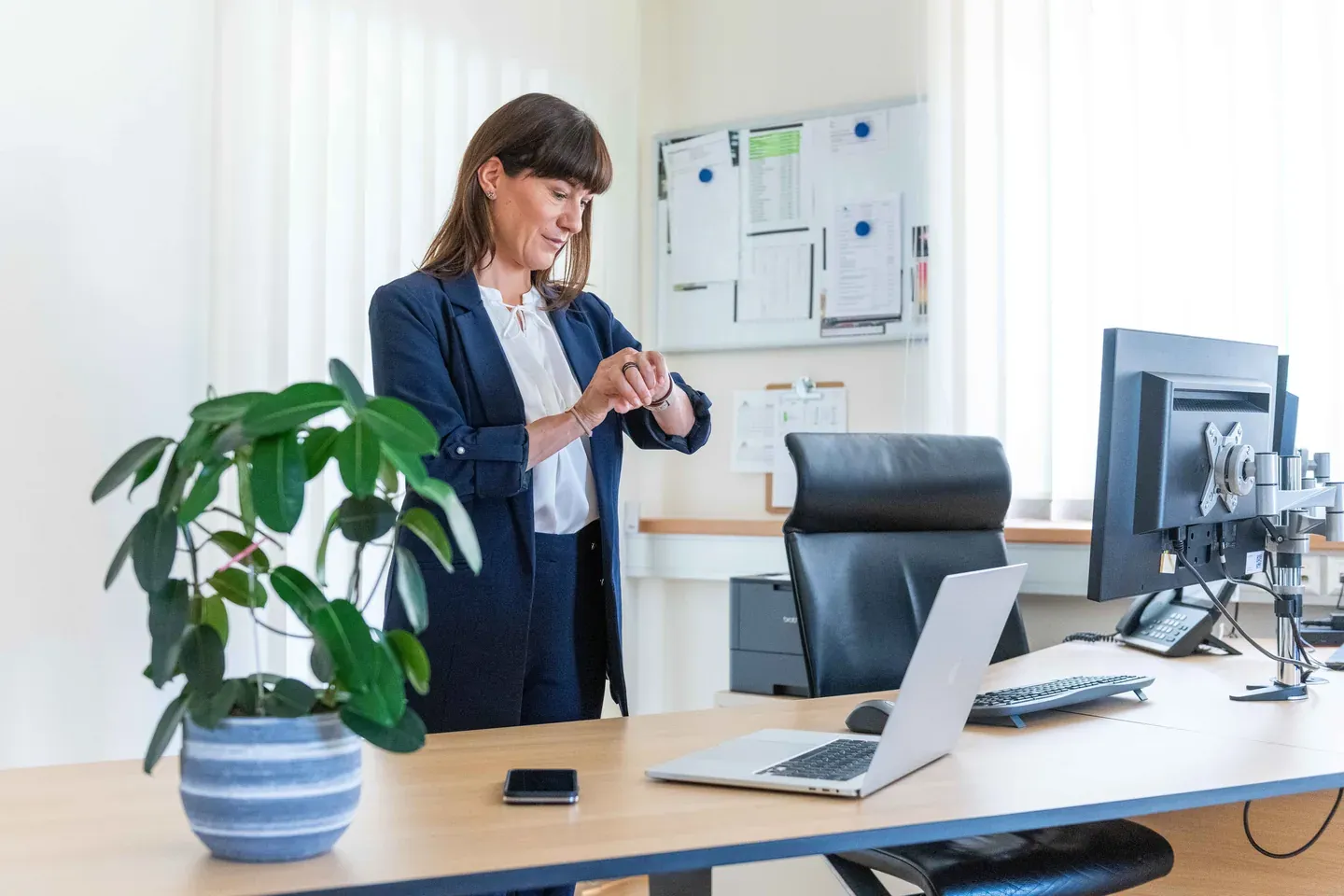 Mitarbeiterin im Buero behaelt die Arbeitszeit im Blick